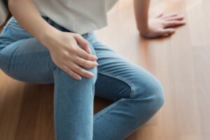 a slip and fall accident victim on the floor with her hand on her knee
