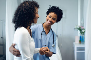 black doctor helping black patient walk again