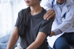 doctor helping patient with shoulder pain