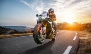 Person riding motorcycle through Escondido near coast.