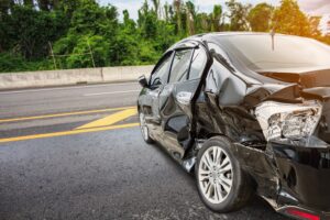 smashed-up black car after a hit-and-run